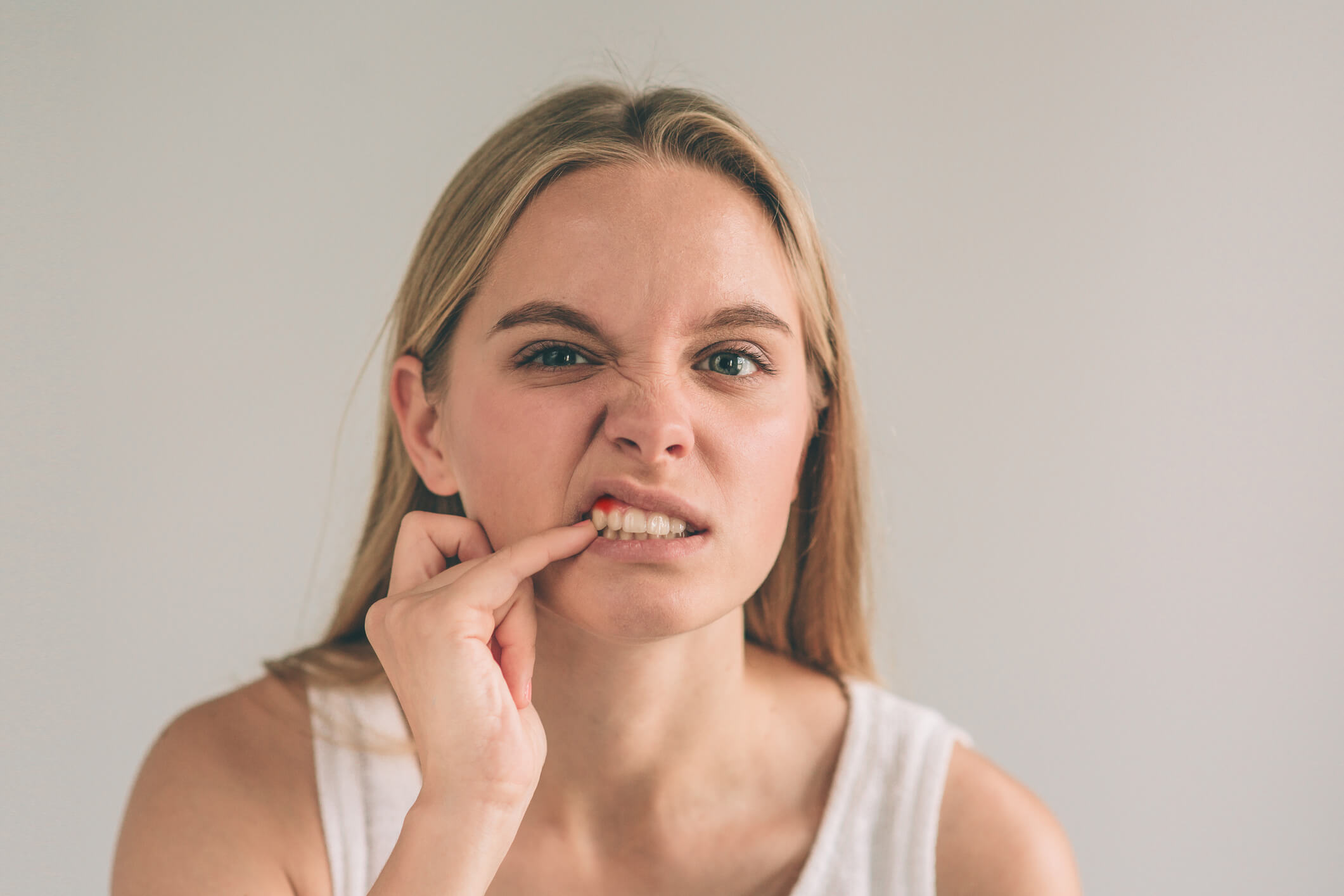 woman with finger in teeth in pain