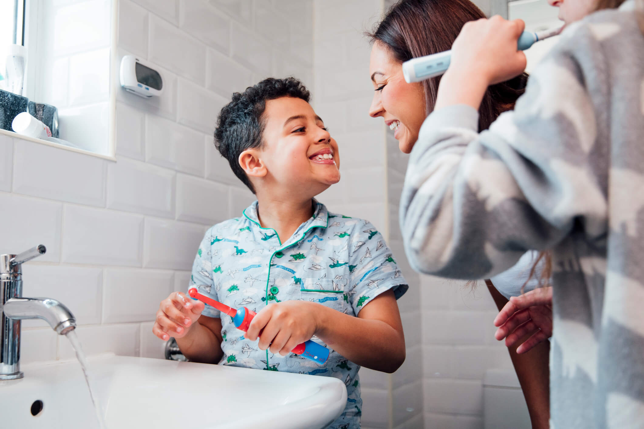 woman and child smiling at each other at sink