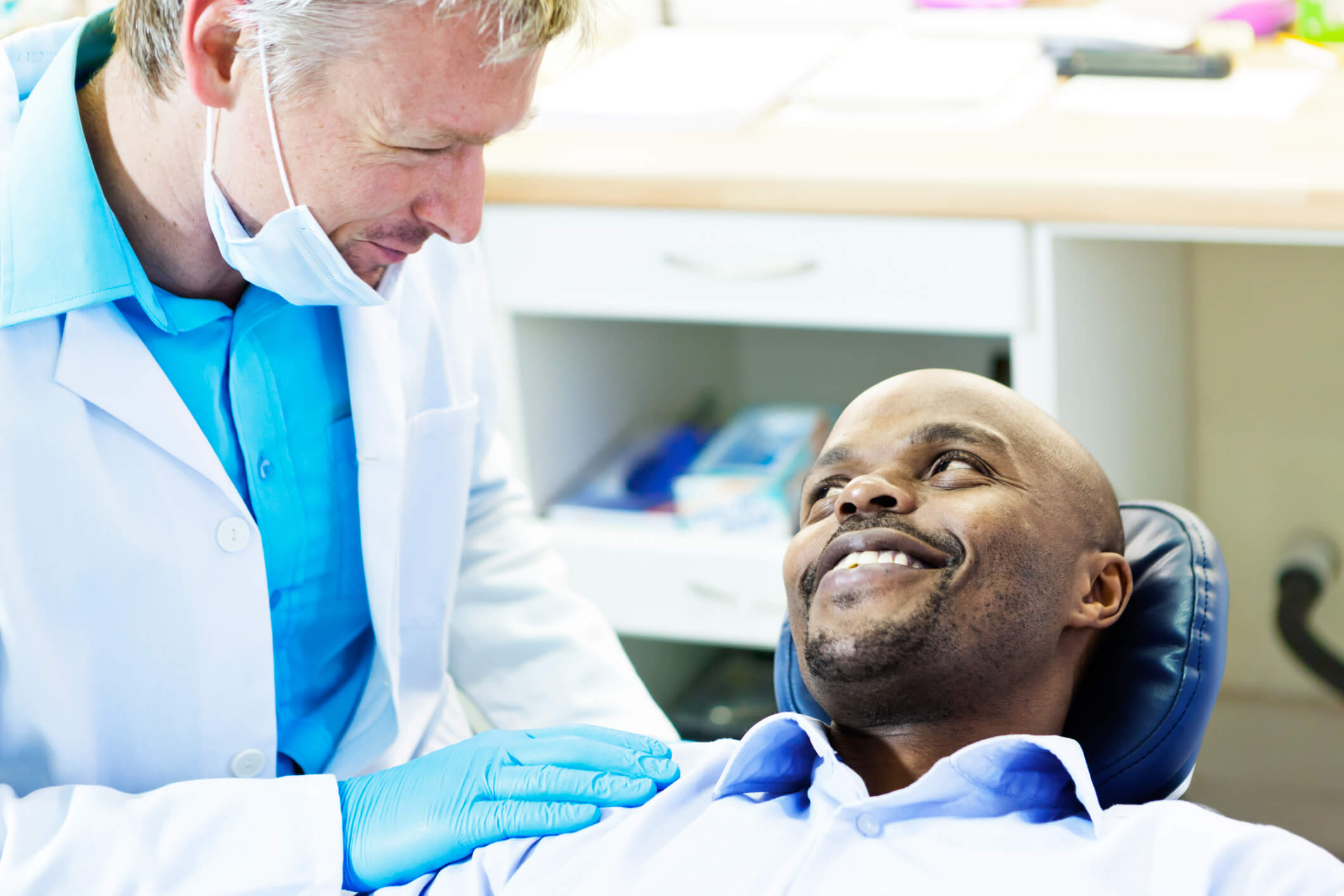 smiling man in dental chair looking at dentist