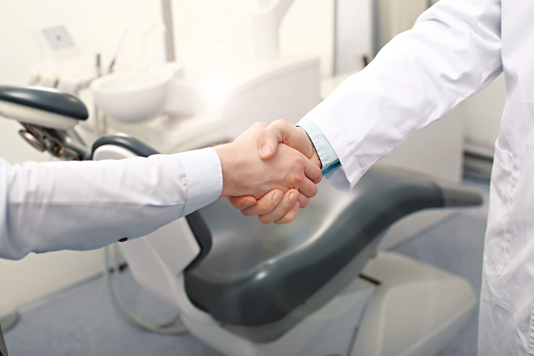 two people in white coats shaking hands