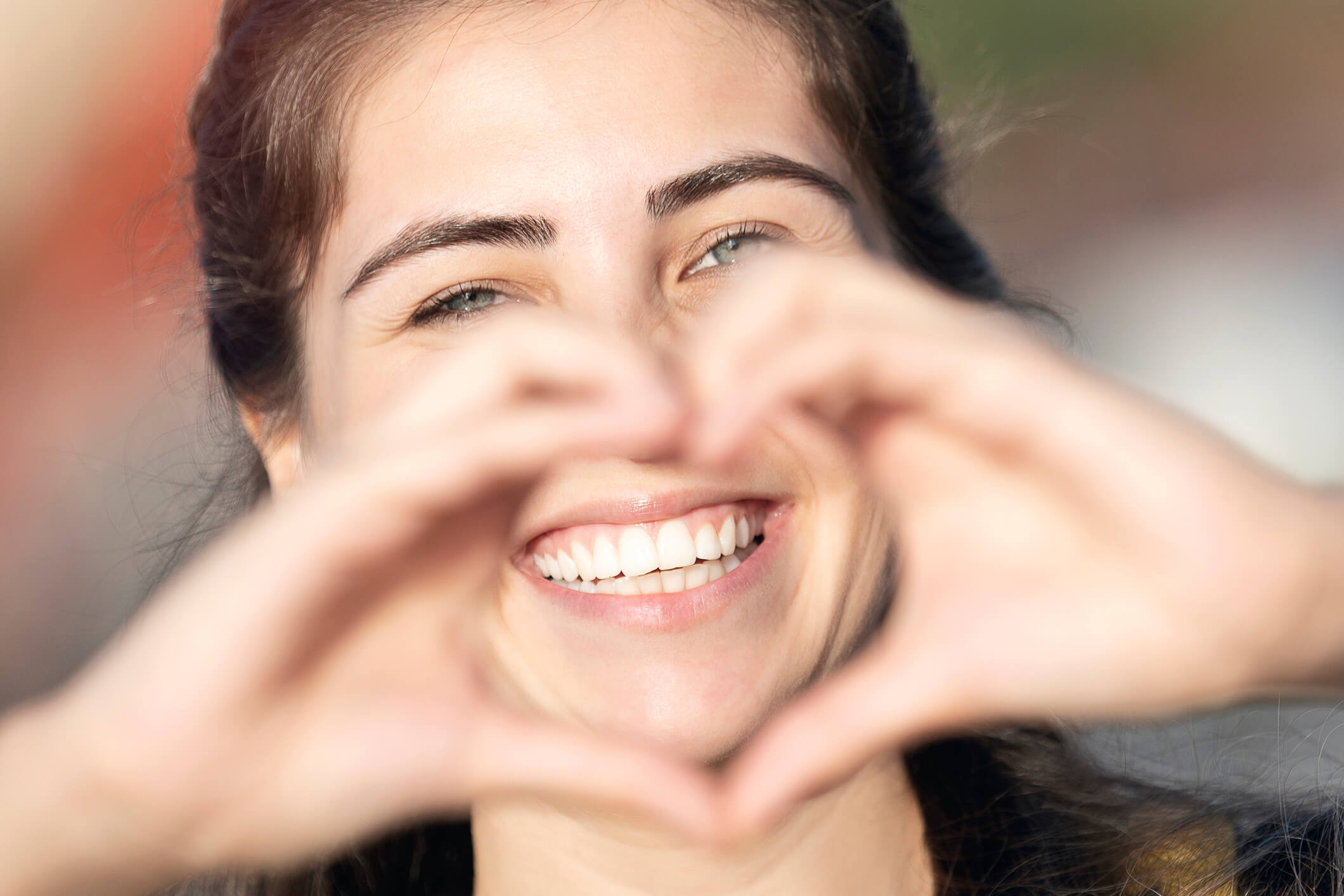 smiling woman making a heart with hands