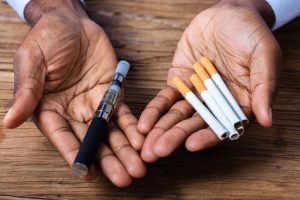 Man Holding Vape And Tobacco Cigarettes