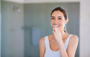 Cropped shot of a young woman brushing her teeth in the bathroom