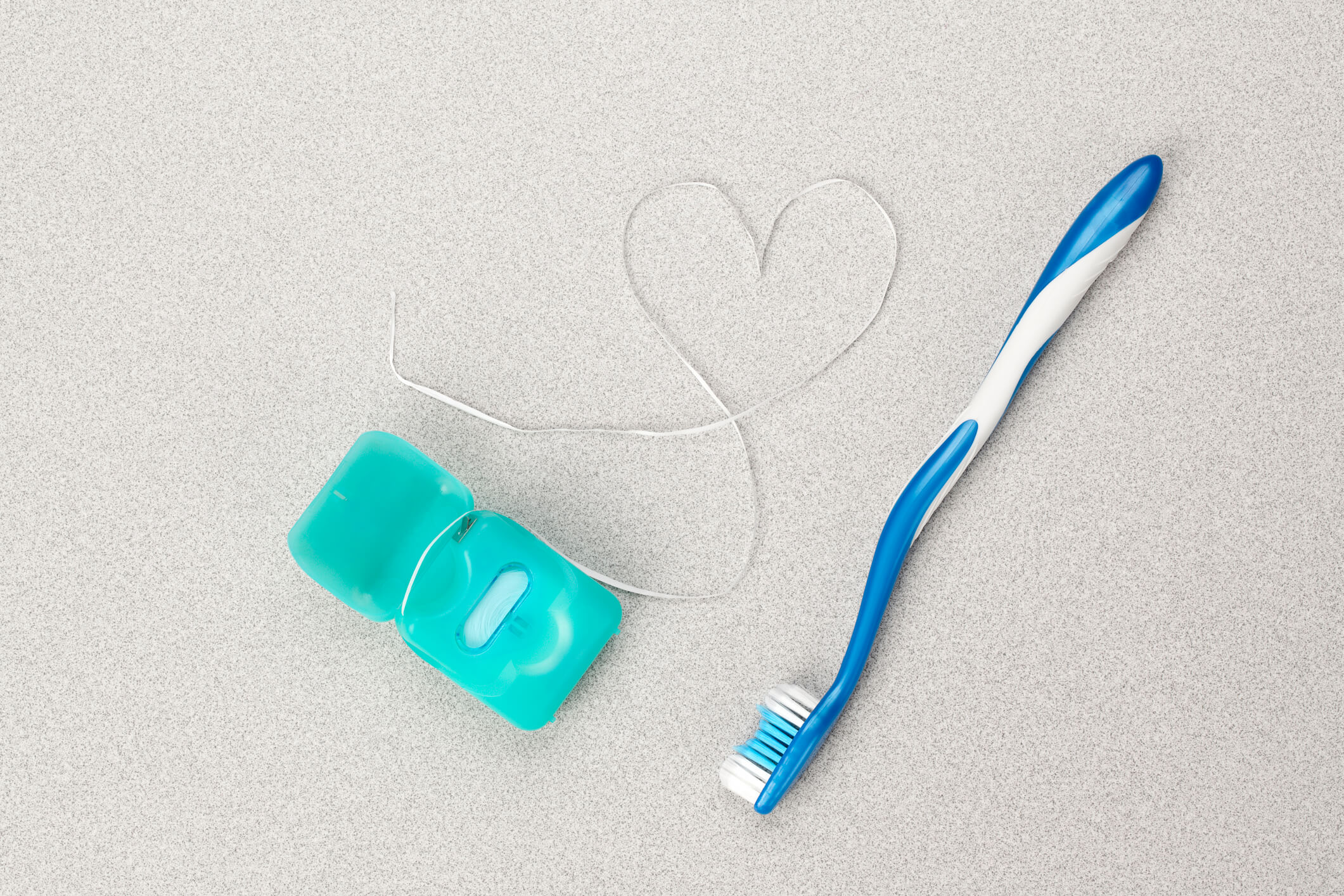 floss in the shape of a heart with toothbrush