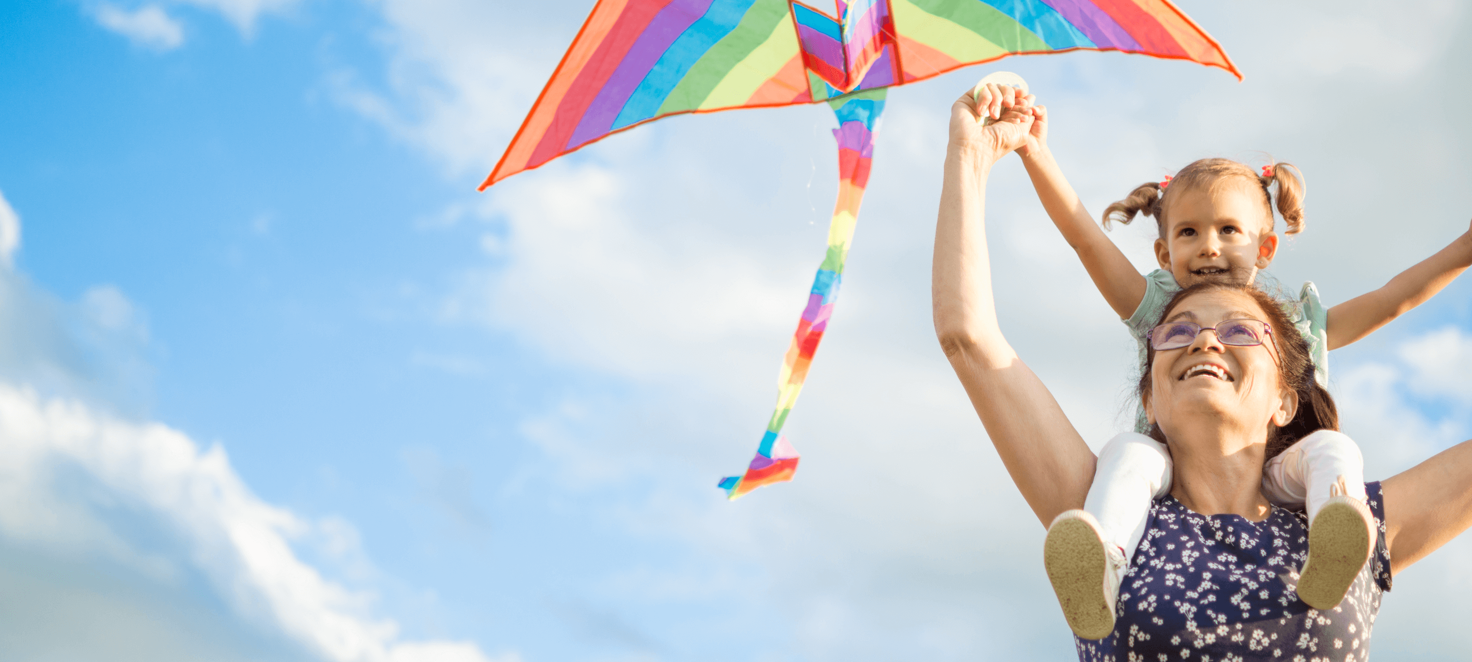 smiling woman flying a kite with child
