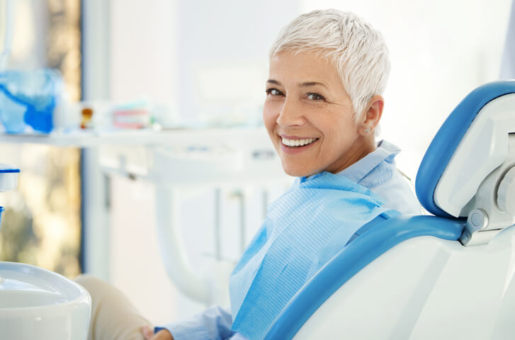 smiling senior woman in dental chair