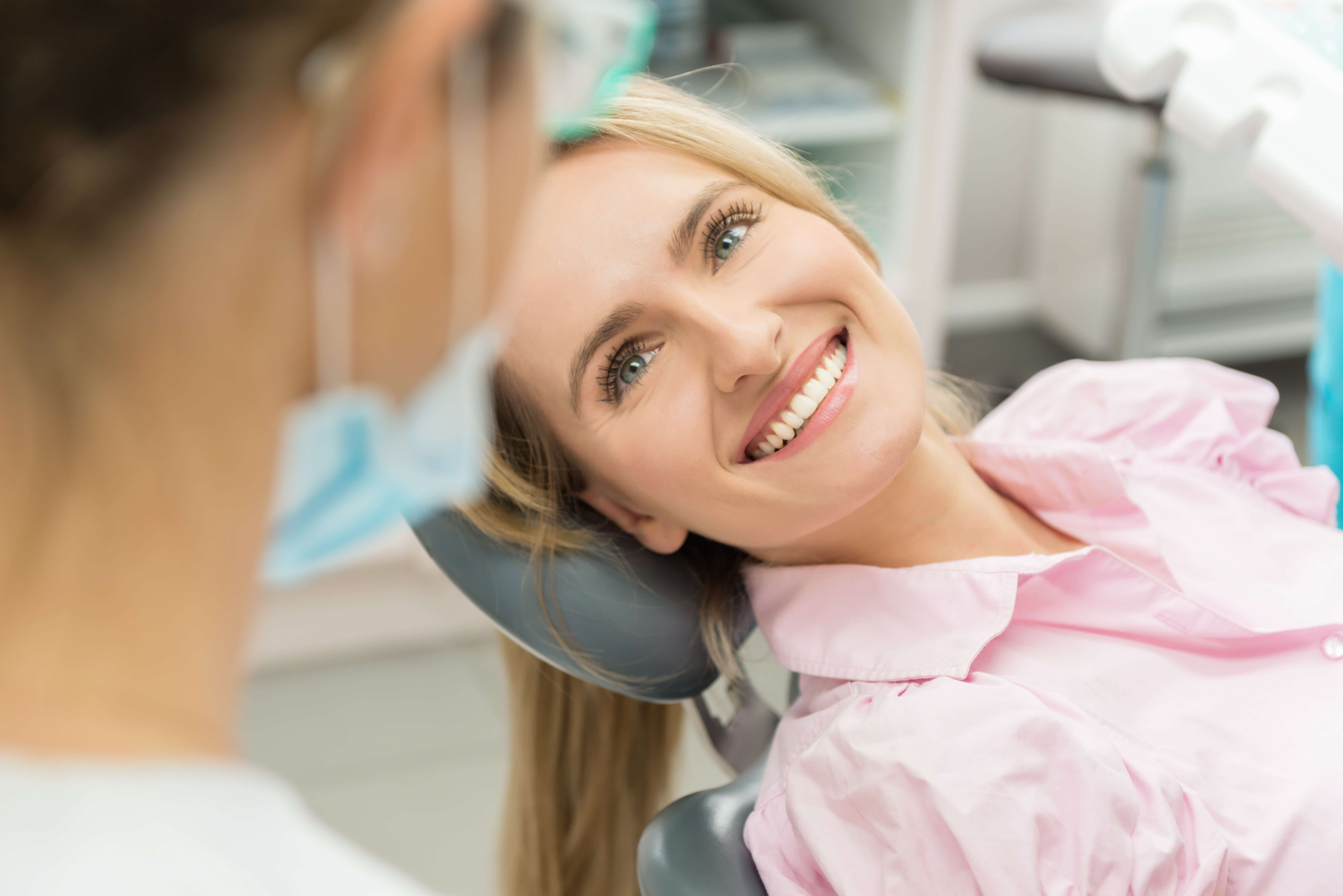 smiling woman in dental chair looking at dentist