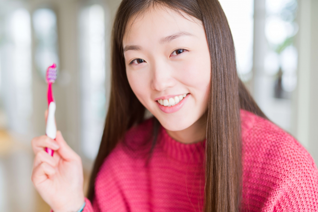 smiling woman holding toothbrush