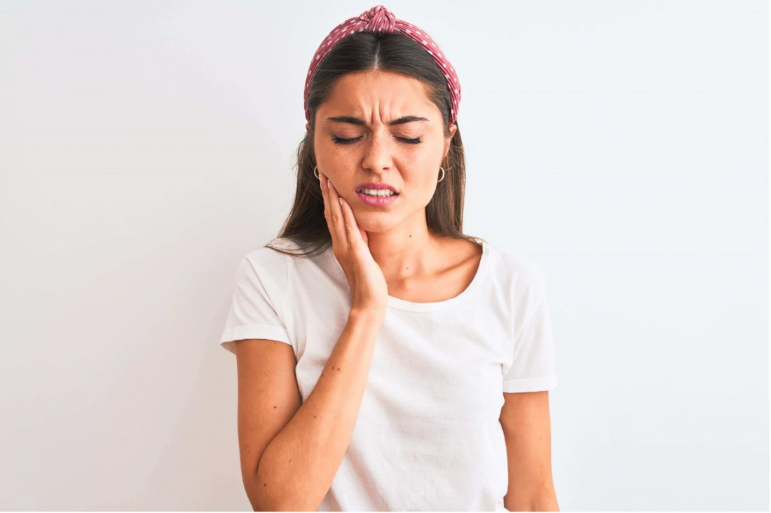 woman holding jaw in pain