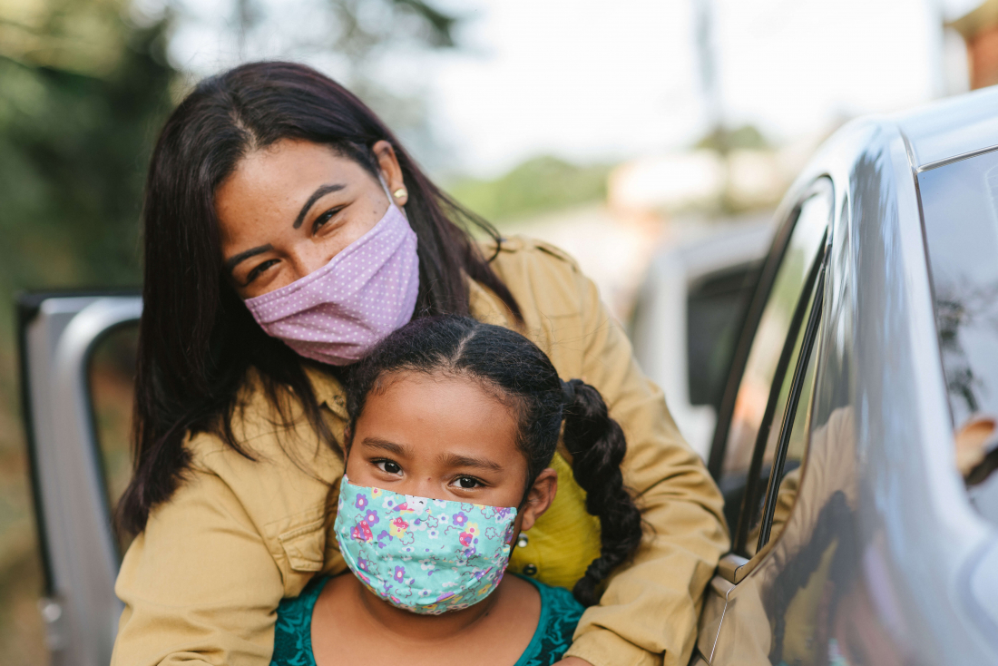 two woman with face masks on