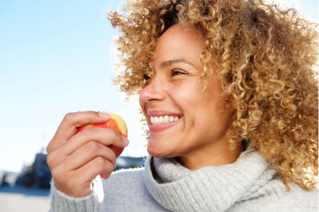 smiling woman holding apple