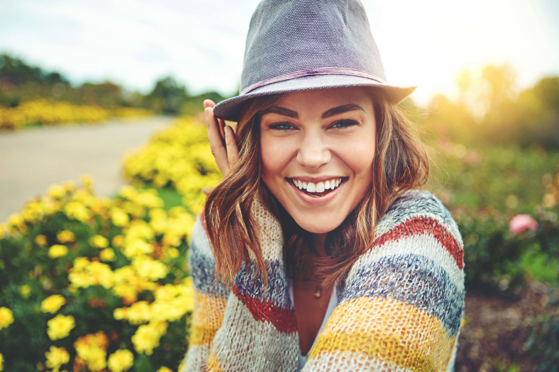 smiling woman with hat in field