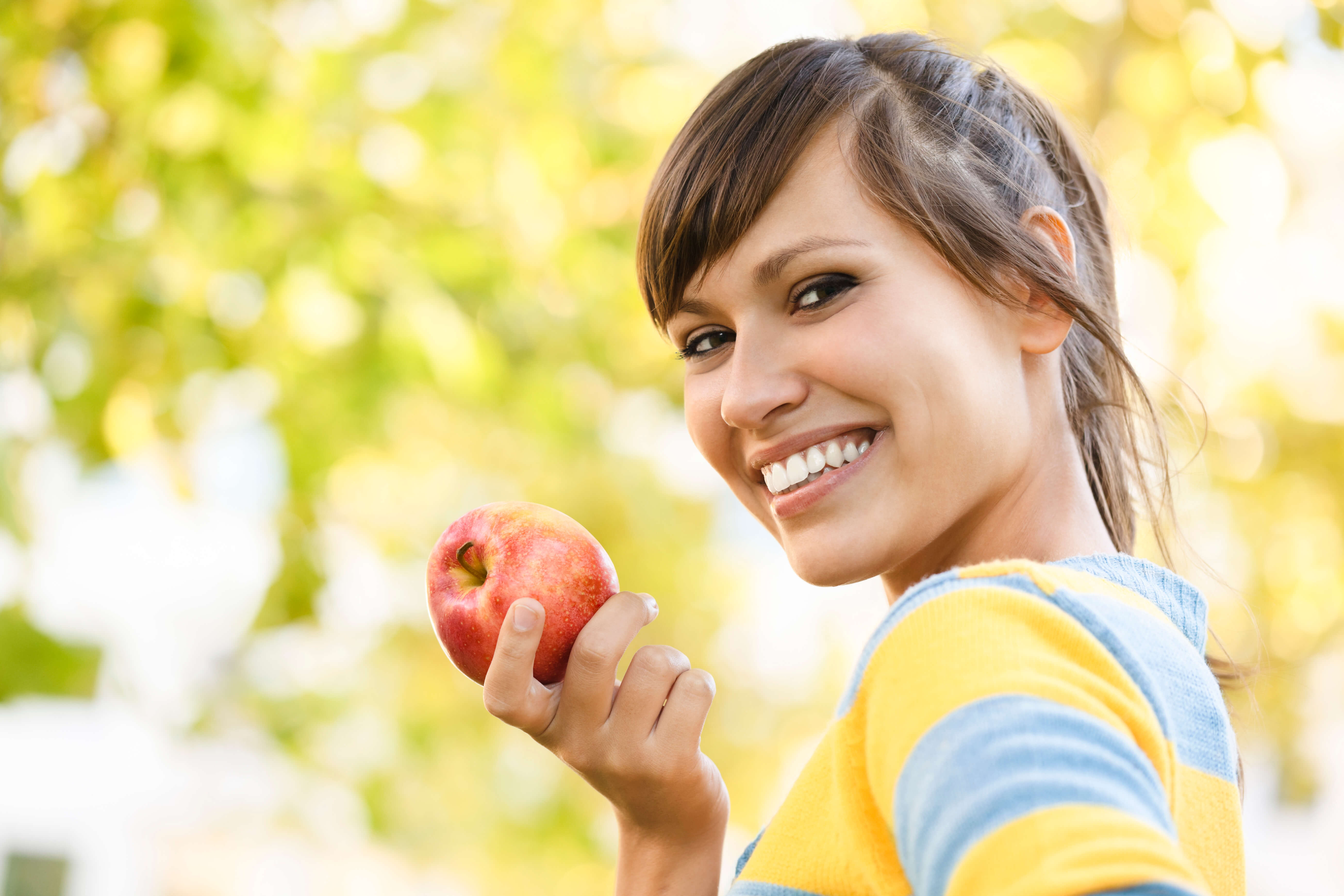 smiling woman holding apple