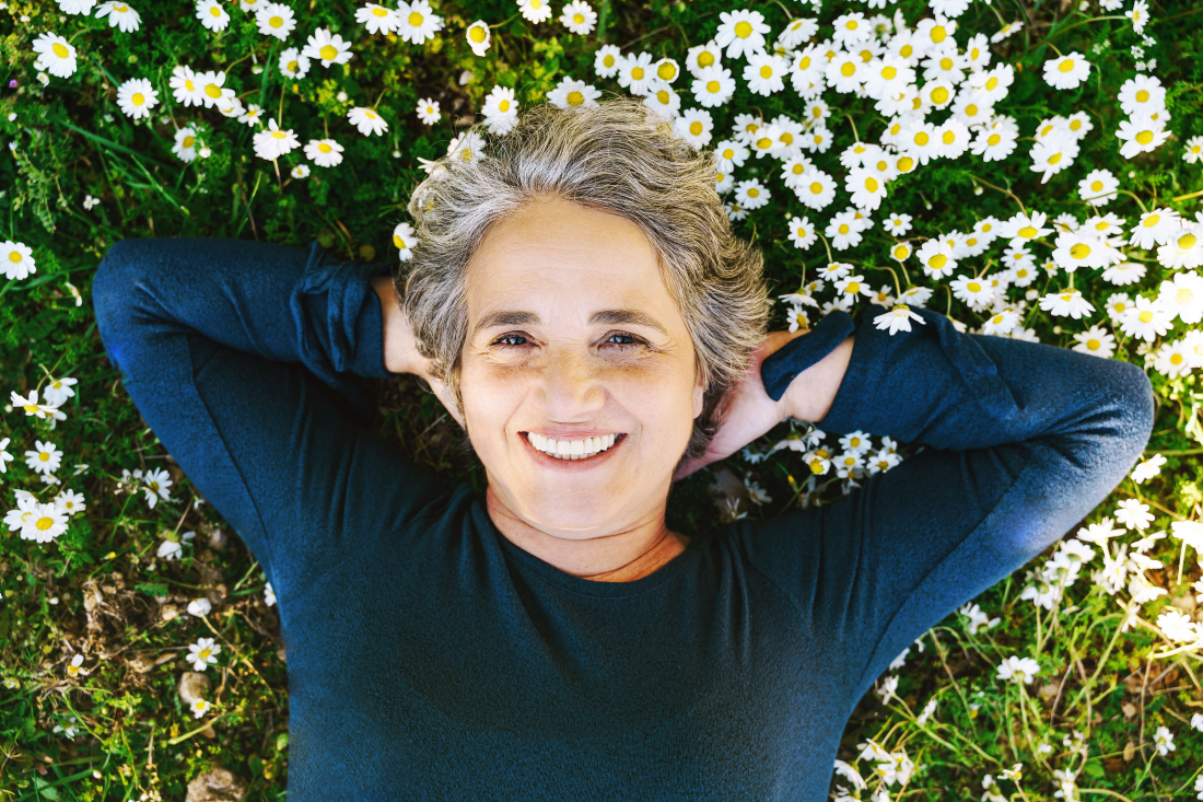 smiling woman laying in spring flowers