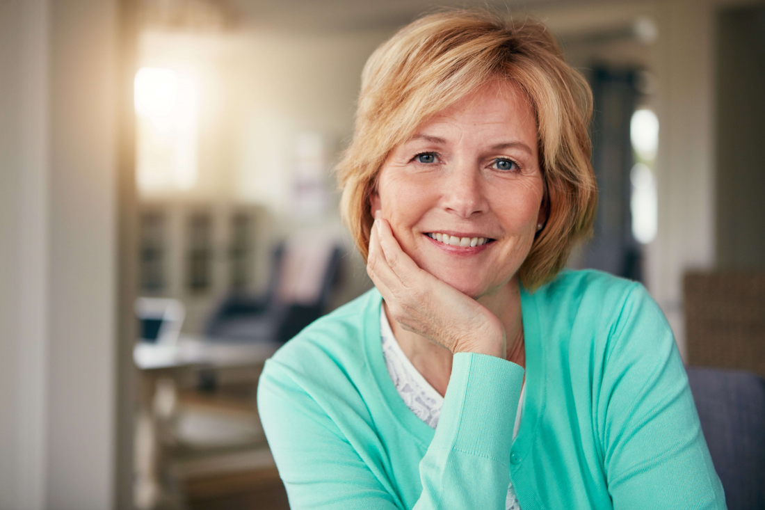 woman smiling with hand on chin