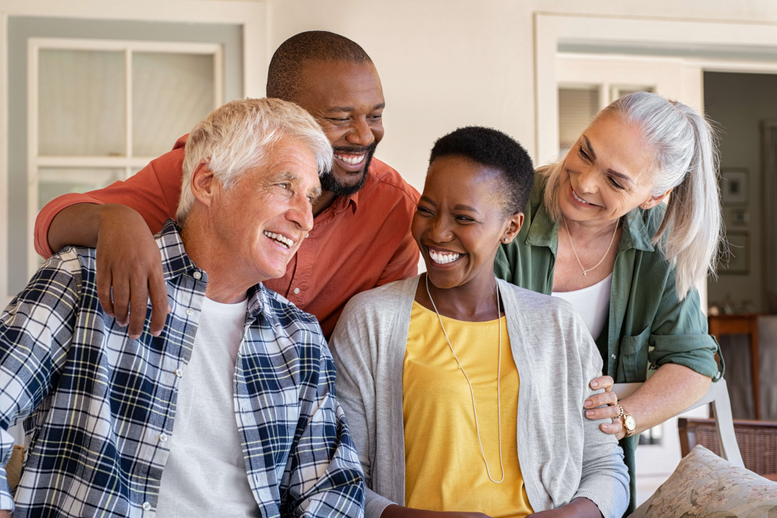 photo of group of 4 people smiling wearing dentures and dental implants