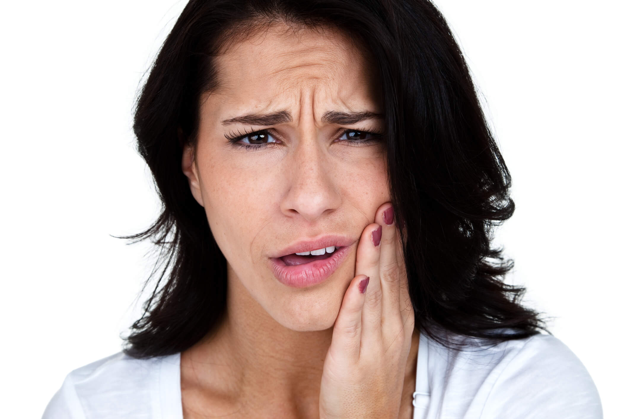 photo of woman in white shirt holding face with tooth pain