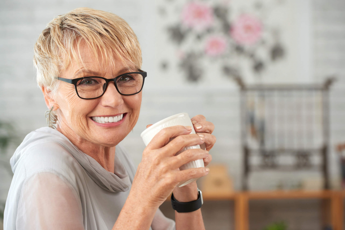 woman smiling after replacing loose dentures